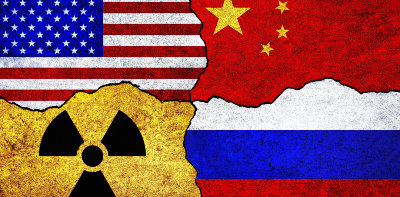 Flags of USA, Russia, China and radiation symbol on a wall.